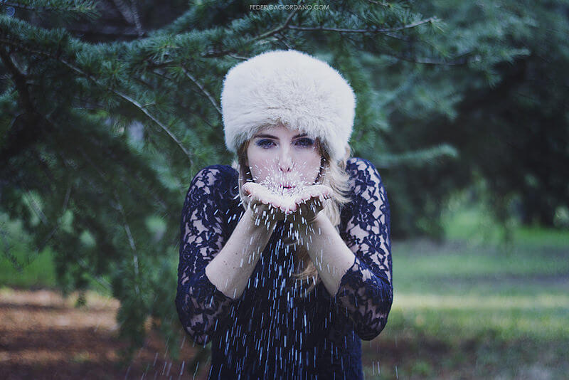 portrait of woman blowing snow