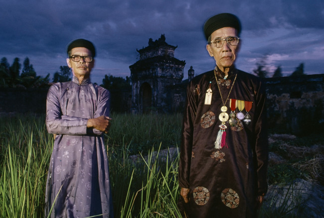 Last of the dying aristocracy: Relatives of Emperor Bảo Đại, stand in their weed-choked garden. Huế, Vietnam, July 1990.