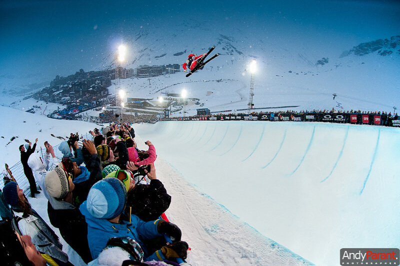 skier jumping in the half-pipe with audience