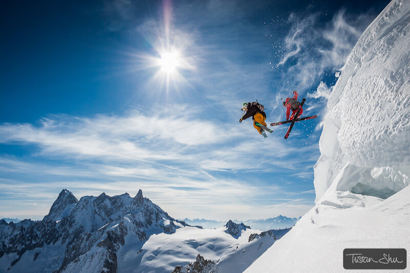 Two skiers jumping off a cliff