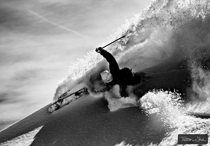 Skier making a turn with powder spraying