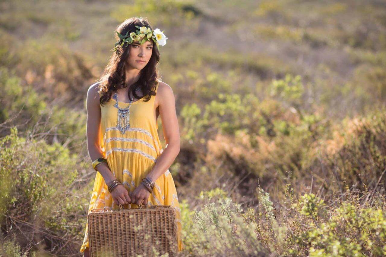 girl poses in field wearing a yellow dress