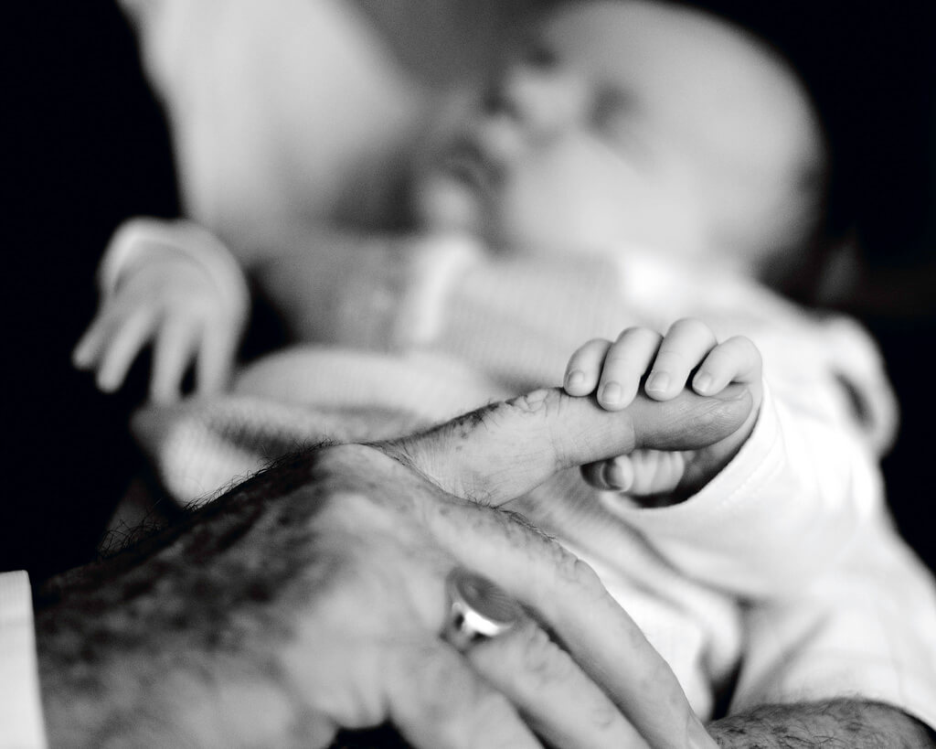 Conor Ogle - baby holding Grandpa's finger